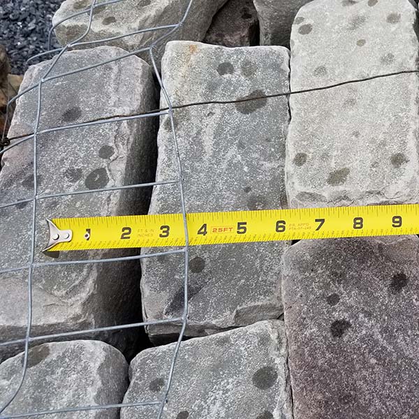 stack of blue cobblestones with measuring tape