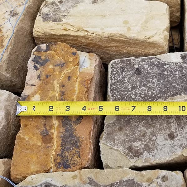 stack of earthtone cobblestones with measuring tape