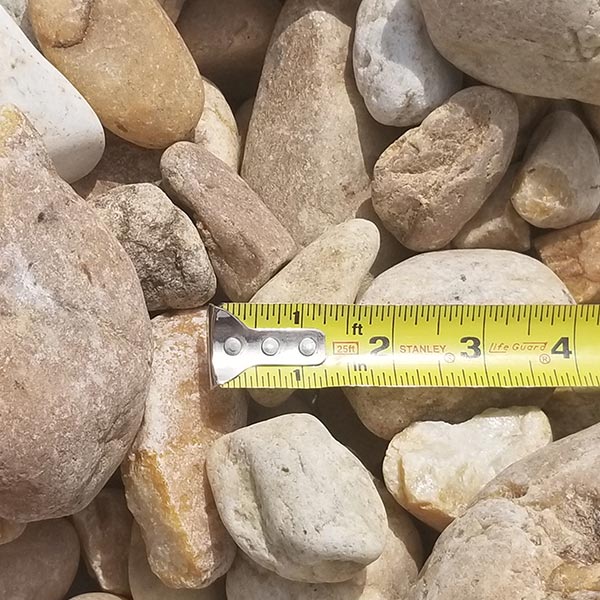 pile of oversized river rock with measuring tape