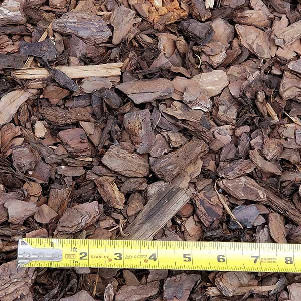 pile of mini pine nuggets with measuring tape